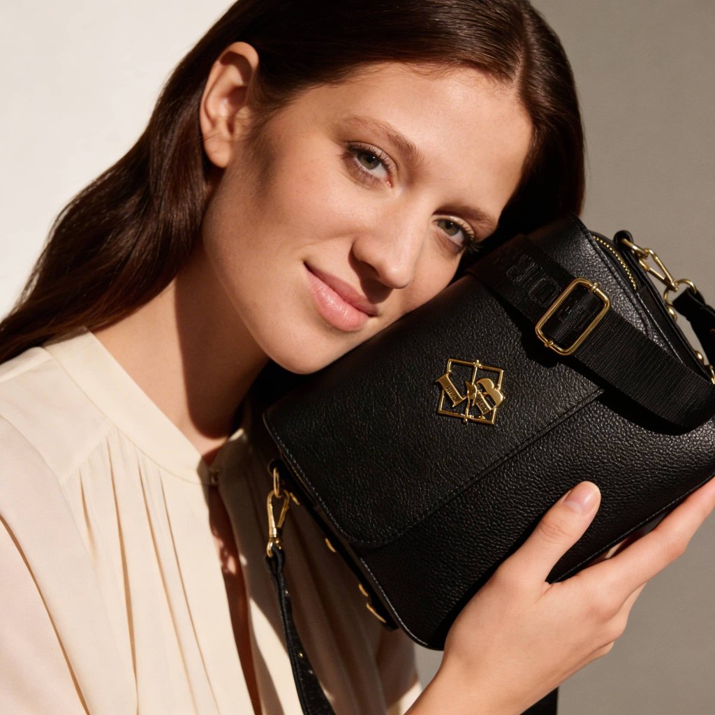 Černá kabelka se zlatým kováním na postavě